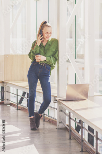Wallpaper Mural Young beautiful woman is standing with a smartphone Torontodigital.ca