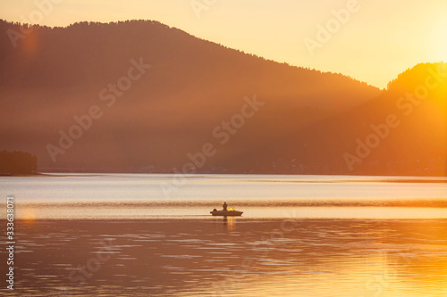 sunset on the sea with a boat and mountains © Ekaterina Shvaygert