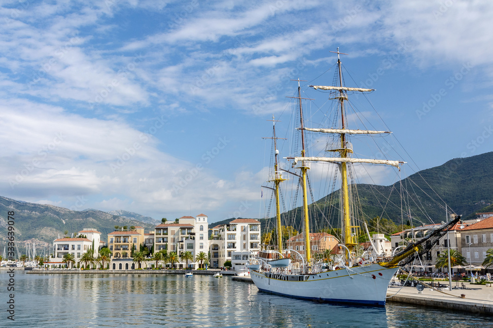 Montenegro Tivat. Embankment with a view of the mountains, pier and sailboat