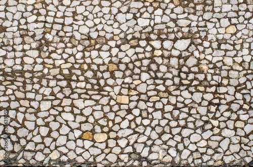 Fragment of a wall made of stones of different sizes held together with mortar, close-up, copy space.