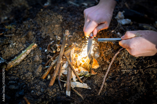 Outdoors makeing fire by flint. Closeup view.