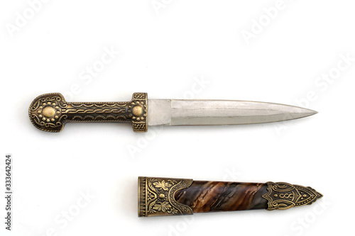 Ornate ceremonial dagger next to a jeweled scabbard Fototapeta