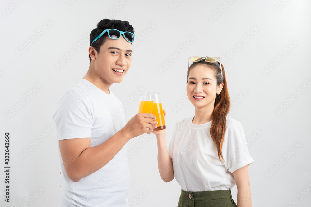 A young couple drink OJ on white background A young couple drink OJ on white background