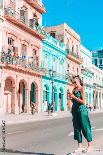 Tourist girl in popular area in Havana, Cuba. Back view of young woman traveler smiling