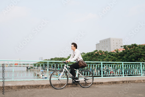 Asian man mad riding bicycle in urban city commuting with speed and hipster trendy transportation