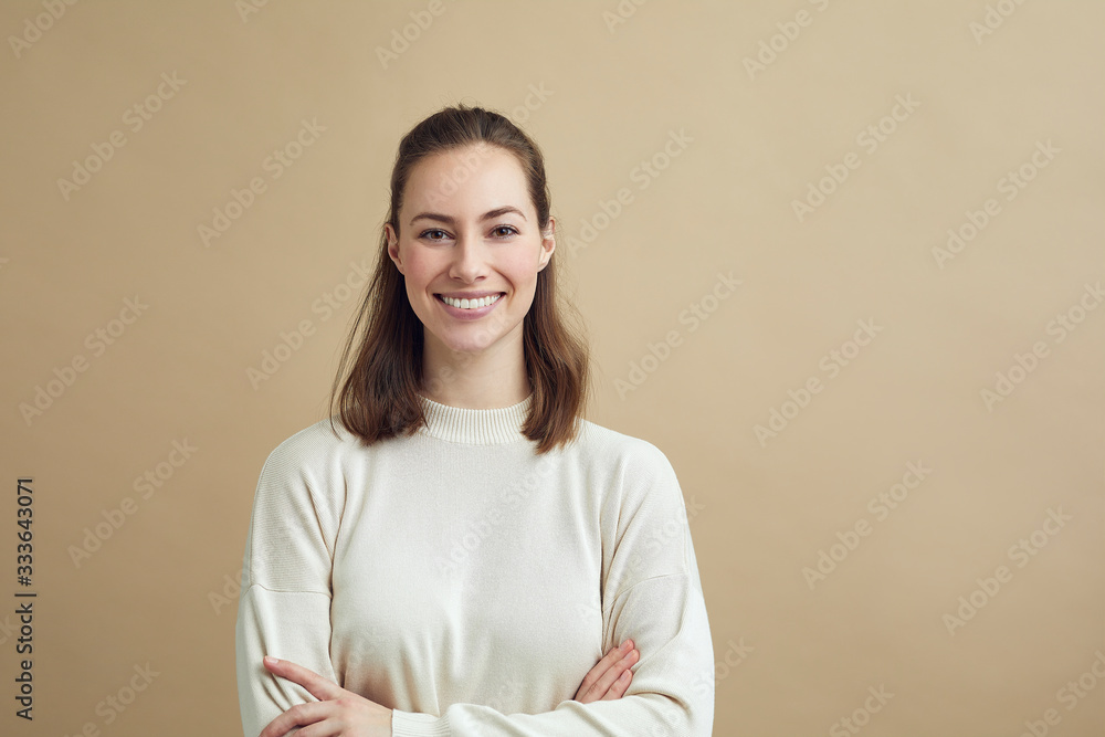Portrait of beautiful girl with crossed arm looking and smiling into the camera Portrait of beautiful girl with crossed arm looking and smiling into the camera