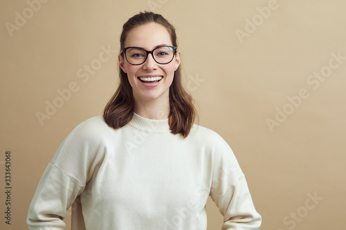 portrait of a young woman with glasses smiling and looking in to the camera