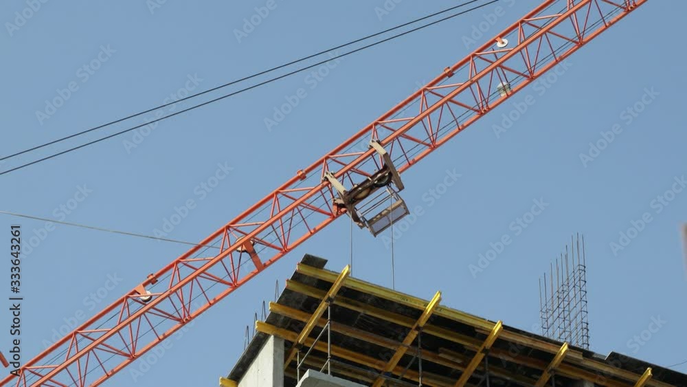 Construction cranes move building materials and work on the construction of multi-storey residential buildings Construction cranes move building materials and work on the construction of multi-storey residential buildings