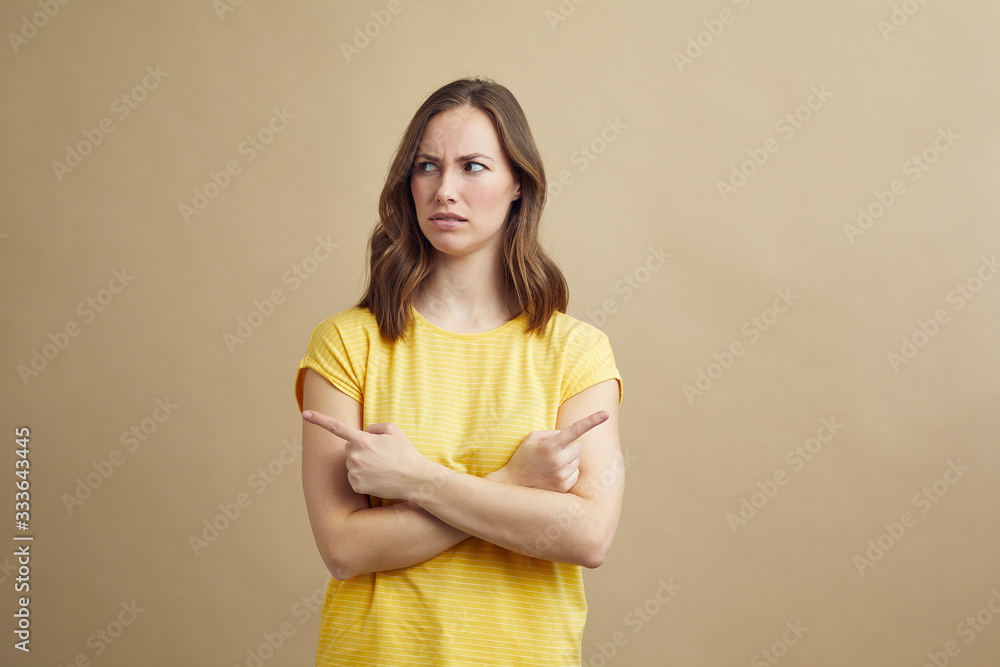 Obraz premium Portrait concept of girl pointing in different directions trying to signal that it has to be the others problems