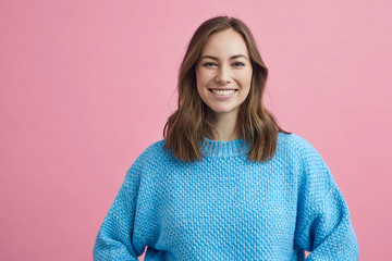 Portrait for beautiful smiling woman on a pink background, colorful portrait