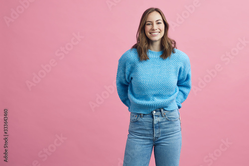 Portrait for beautiful smiling woman on a pink background, colorful portrait photo