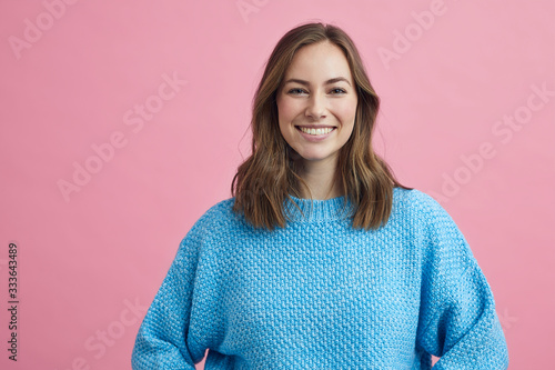Portrait for beautiful smiling woman on a pink background, colorful portrait