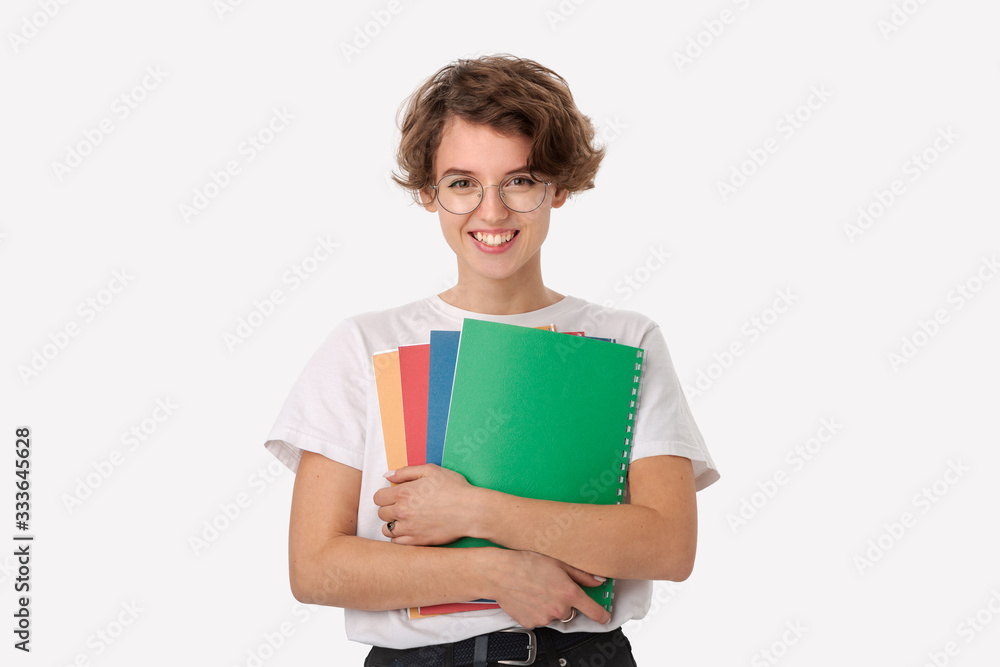 Female student in a white shirt and eyeglasses holding colorful folders Female student in a white shirt and eyeglasses holding colorful folders