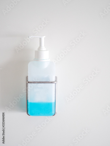 Bottle of  hand disinfectant in the white wall with copy space