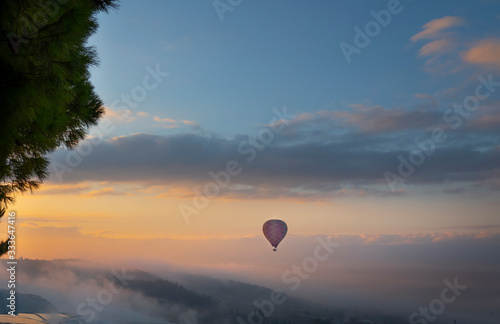 A Balloon flying with colourful sunrise sky and cloud at view point of Pamukkale, Turkey.
