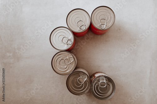 Six can of food in C shape on grey background. Top view flat lay