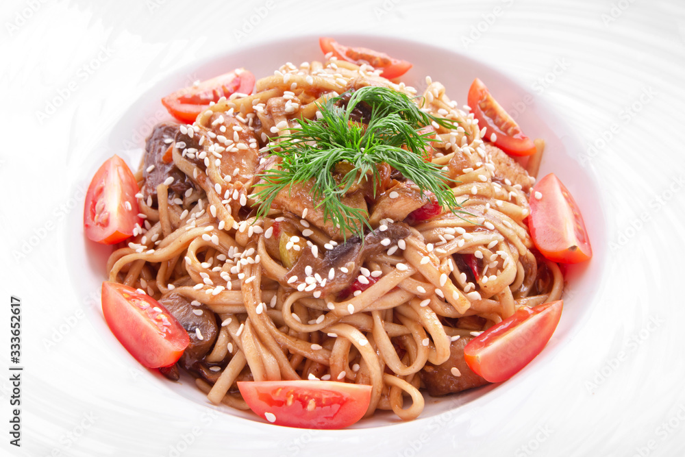 Italian pasta with cherry tomatoes, mushrooms, sesame and dill in a round plate. isolated on white Italian pasta with cherry tomatoes, mushrooms, sesame and dill in a round plate. isolated on white