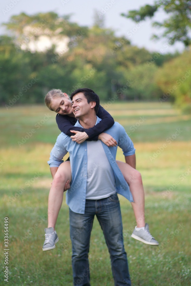 Fototapeta premium European couples, men and women Showing love to each other in the garden. During the holidays, warm and comfortable holidays in the fields and large trees. Who are planning a marriage