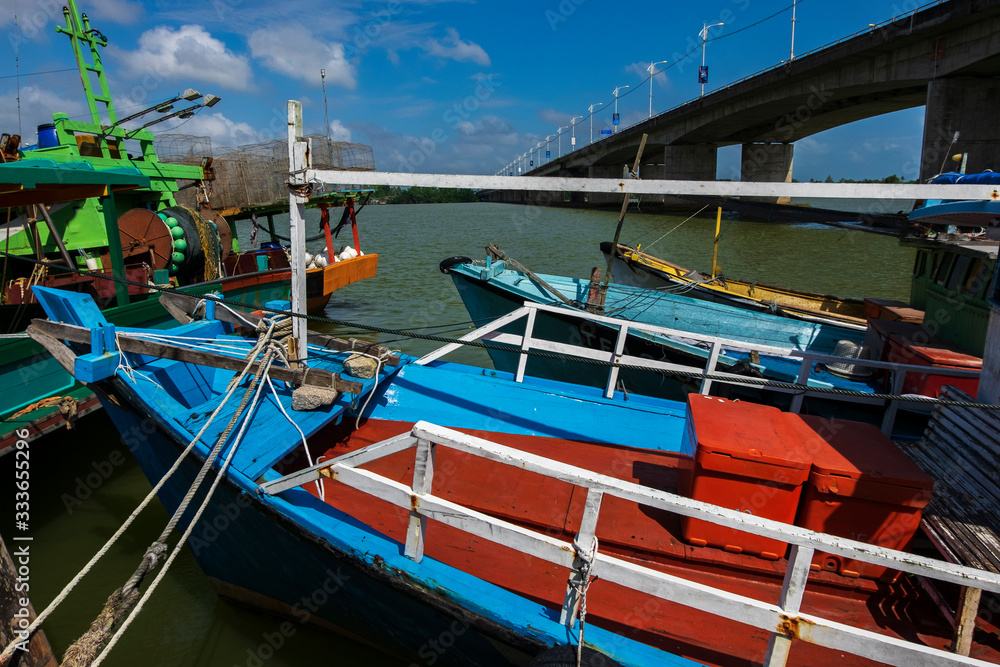 Traditional fishing boat moored at village located in Terengganu, Malaysia under blue sky background