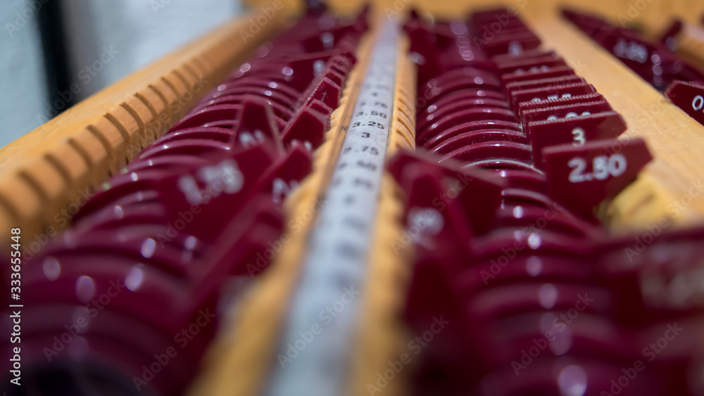 Close up of old-fashioned ophthalmologist lens rack. Shadow depth field. Green lenses. Close up of old-fashioned ophthalmologist lens rack. Shadow depth field. Green lenses.