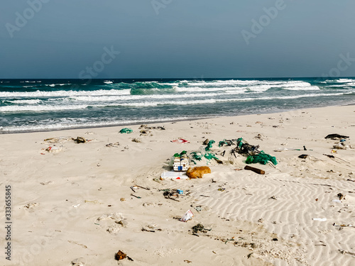 Plastic bottles and other rubbish thrown on the sandy seashore, trash on the sea beach. ecological problem. © Максим Ирха