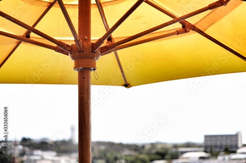 Yellow sun umbrella with wooden supports