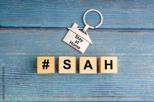 Concept image a wooden block and word - #SAH ( STAY AT HOME ) on wooden background. Coronavirus and Covid-19 Concept