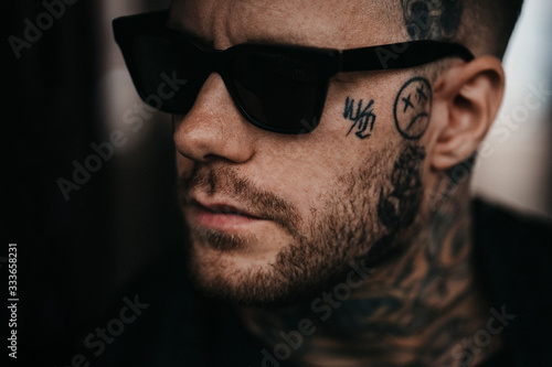 Portrait eines jungen muskulöser Mannes mit Tattoos und Sonnenbrille 