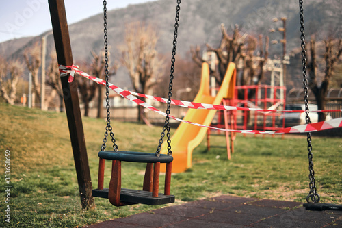 Emplty swing in a fordidden playgound closed due to the coronavirus outbreak in italy
