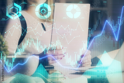 Double exposure of hands making notes with forex chart huds. Stock market concept.