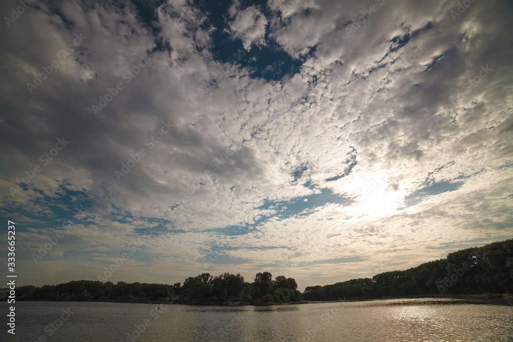 Blue sky with clouds over river during sunset. Desna river, Ukraine.