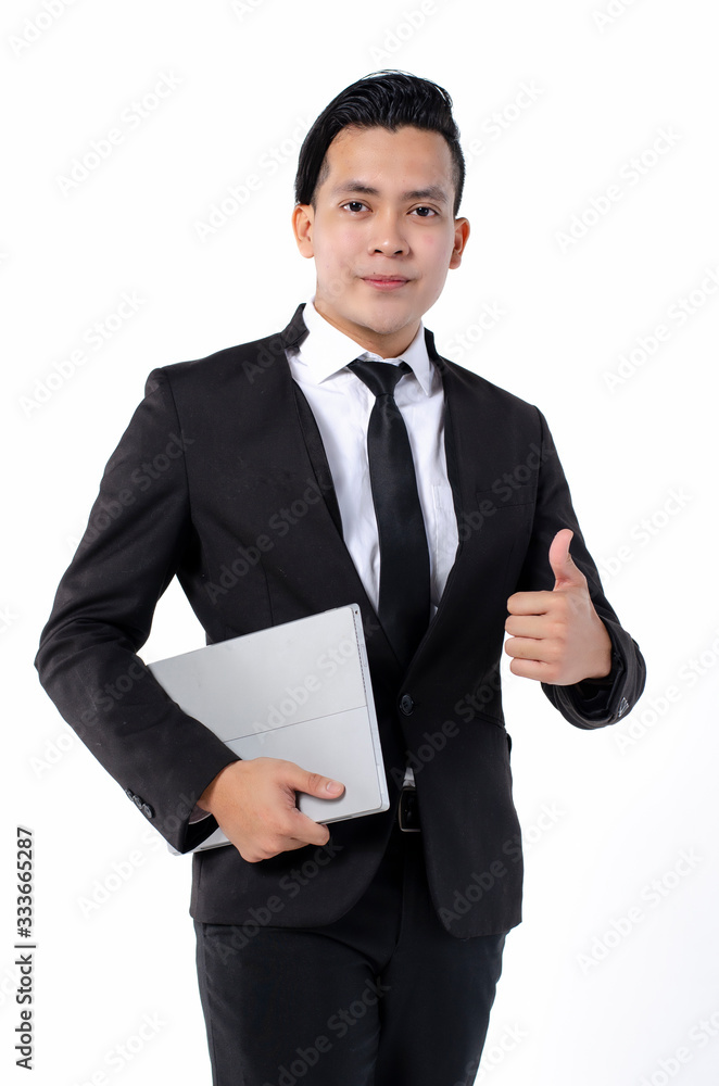 Confident young handsome businessman in black suit holding laptop and smiling while standing against white background Confident young handsome businessman in black suit holding laptop and smiling while standing against white background