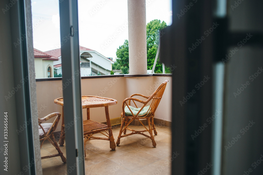 Room that opens with doors onto a terrace with wicker table and chairs. Room that opens with doors onto a terrace with wicker table and chairs.