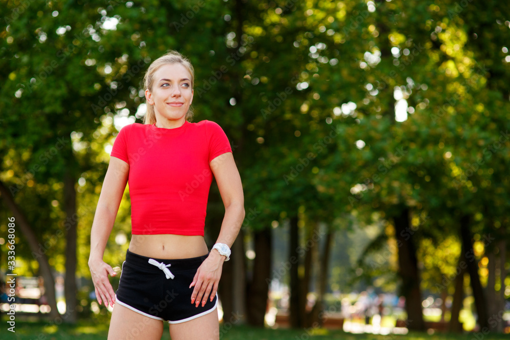 A young blonde girl is engaged in sports in the park, a woman does a warm-up in the street. Active outdoor training A young blonde girl is engaged in sports in the park, a woman does a warm-up in the street. Active outdoor training