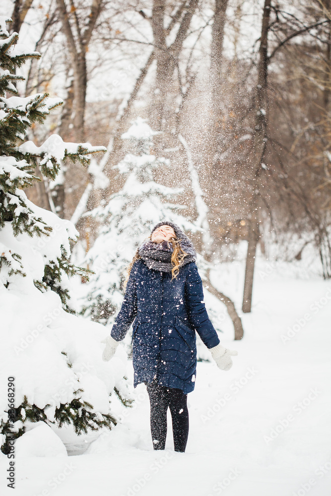 A girl of European appearance walks in the Park, forest, winter and snow, dressed in warm clothes, hat, jacket, scarf, rest, Hiking A girl of European appearance walks in the Park, forest, winter and snow, dressed in warm clothes, hat, jacket, scarf, rest, Hiking