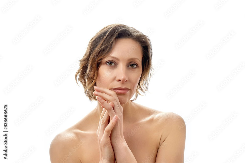 Beautiful young woman looking at the camera with her hands clasped together. Clean skin. Naked to the shoulders posing. isolated white background. Beautiful young woman looking at the camera with her hands clasped together. Clean skin. Naked to the shoulders posing. isolated white background.