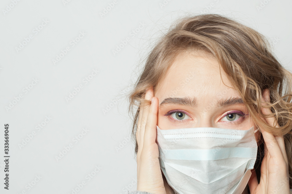 Young unhappy woman wearing a face mask on white background. Protection against virus Young unhappy woman wearing a face mask on white background. Protection against virus