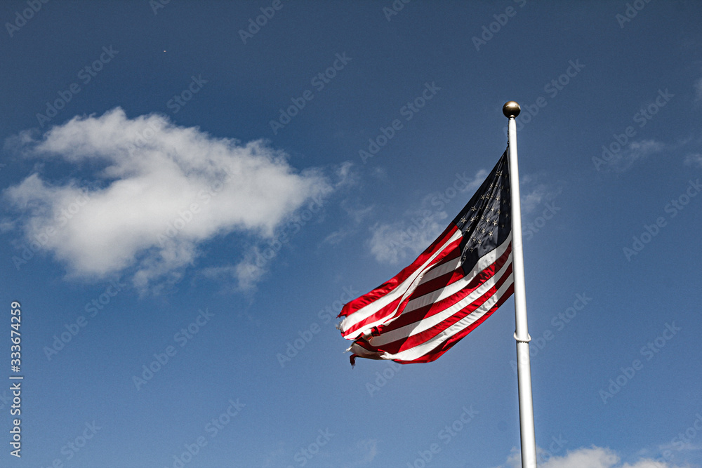american flag waving in the wind against blue sky