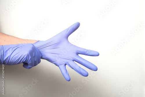 Fototapeta Naklejka Na Ścianę i Meble -  closeup of hands of doctor wearing a latex gloves to protect against the coronavirus pandemic on white background