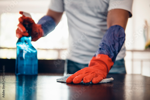 Cropped shot of an asian man cleaning a kitchen table at home