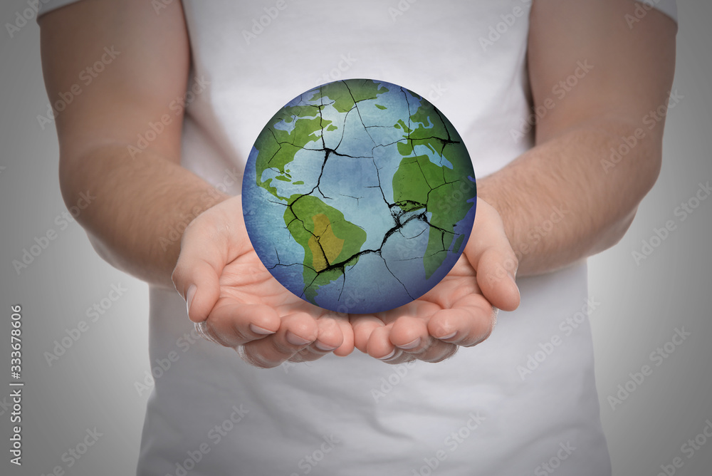 Man holding Earth with medical mask on light background, closeup. Concept of coronavirus outbreak Man holding Earth with medical mask on light background, closeup. Concept of coronavirus outbreak