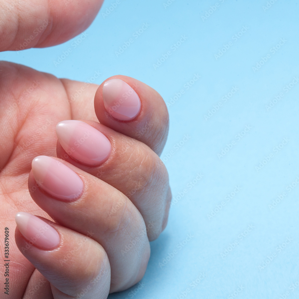 Women's hands with perfect Nude manicure. Nail Polish is a natural pale pink shade. Women's hands with perfect Nude manicure. Nail Polish is a natural pale pink shade.