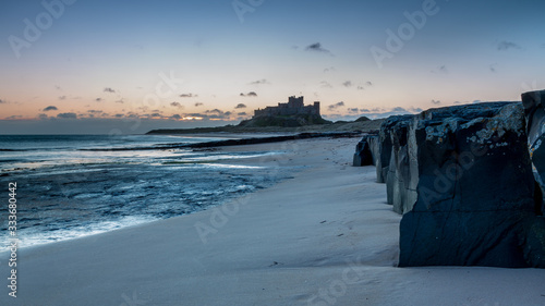 Sunrise at Bamburgh Beach, on the coast of Northumberland, UK, with Bamburgh Castle in background.