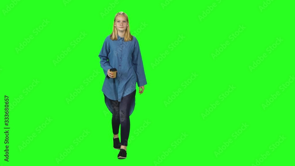 Blonde teenager girl calmly walking on green screen background. Chroma key, 4k shot. Front view. Blonde teenager girl calmly walking on green screen background. Chroma key, 4k shot. Front view.