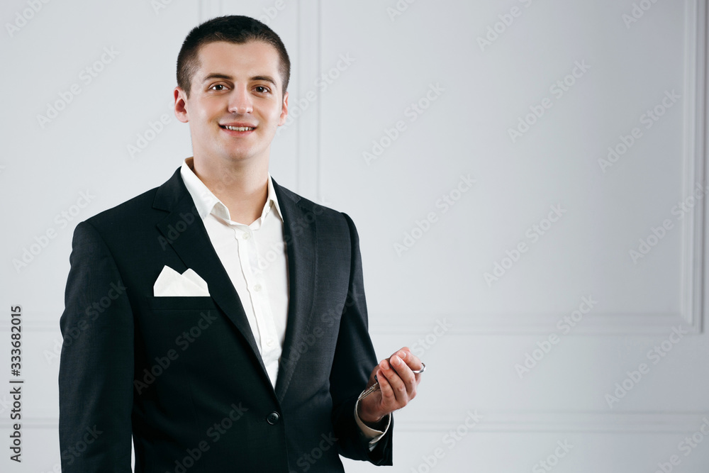 Handsome young businessman in a suit holding car keys Handsome young businessman in a suit holding car keys