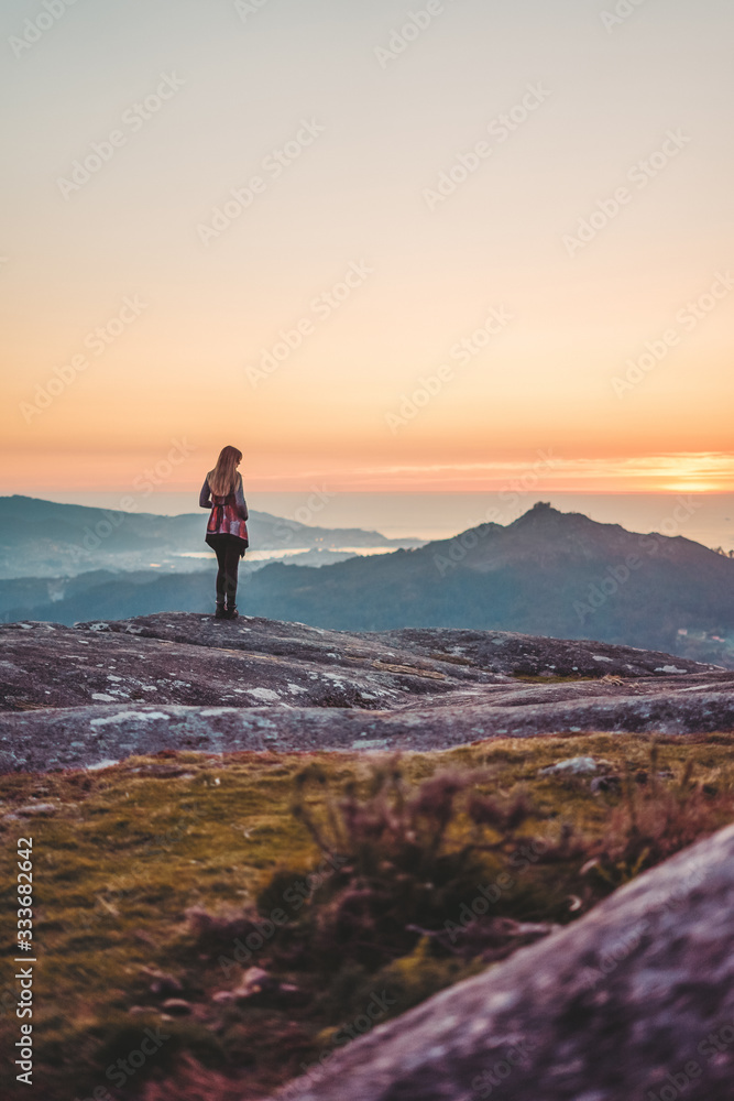 Silhouette of a woman contemplating the sunset from Mount Galiñeiro in Vigo, Galicia, Spain