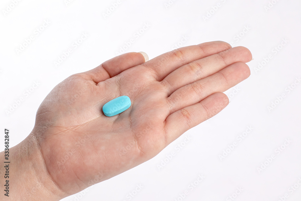 Blue vitamine in hand. medicines and vitamins Blue vitamine in hand. medicines and vitamins
