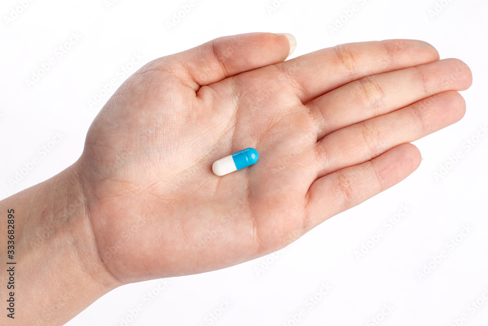 Blue and white pill in hand. medicines and vitamins Blue and white pill in hand. medicines and vitamins