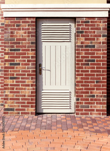 white wooden door red brick wall