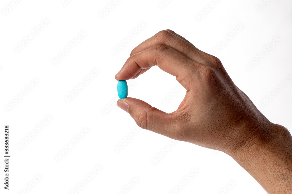 Blue vitamine in thumbs hand. medicines and vitamins Blue vitamine in thumbs hand. medicines and vitamins